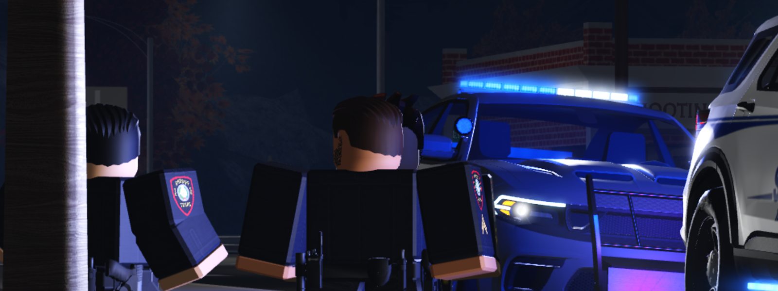 Two deputies talking beside their patrol cars at night